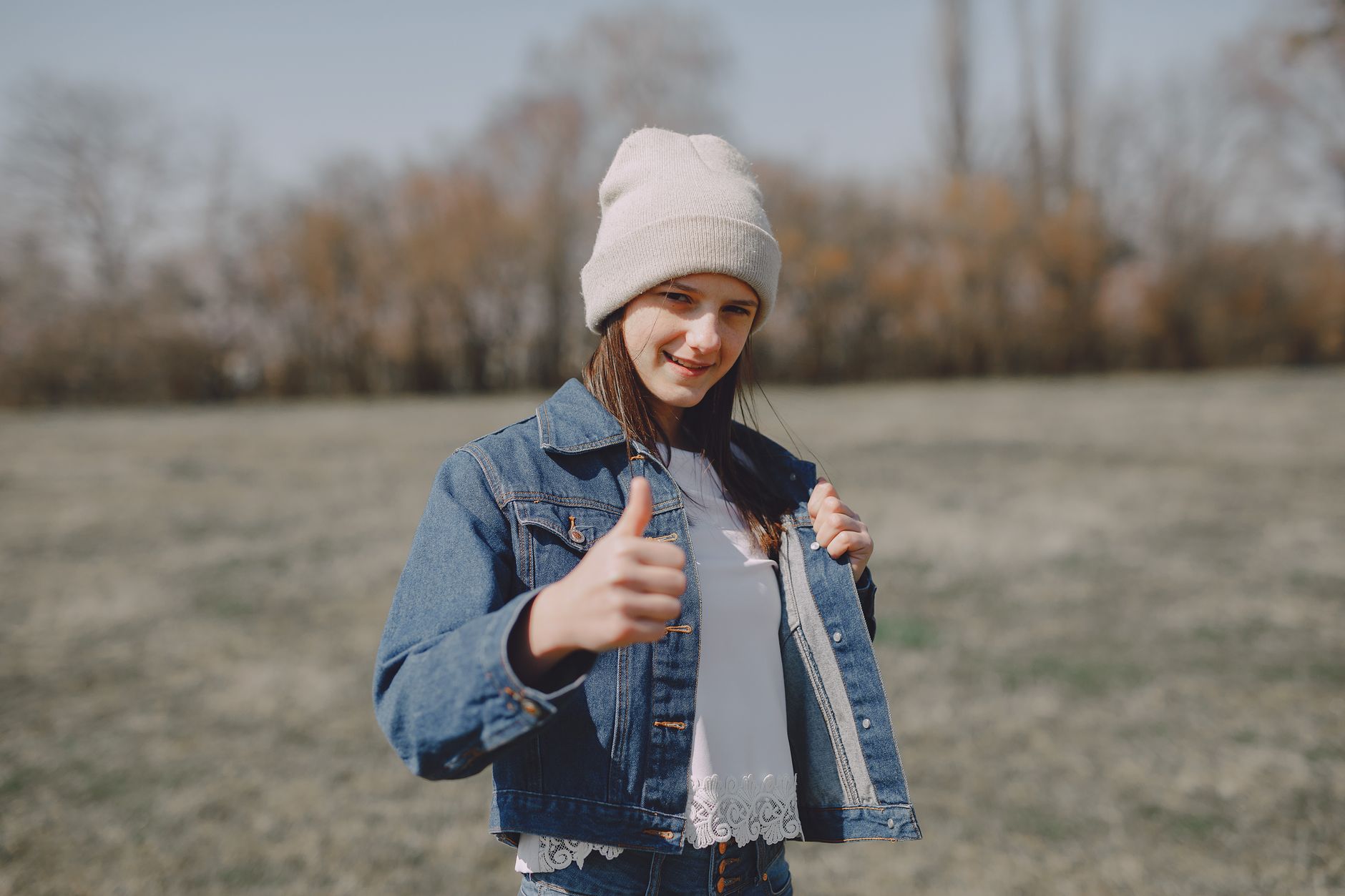 happy girl showing thumbs up in countryside