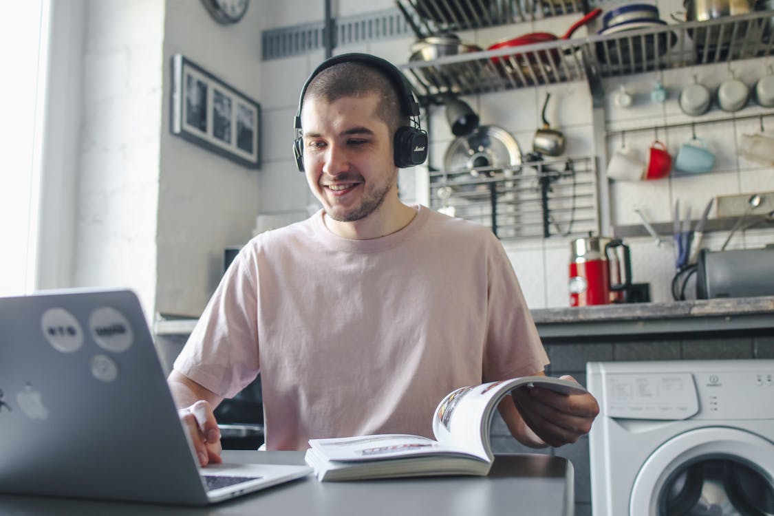 Adult learner studying at table with book and laptop