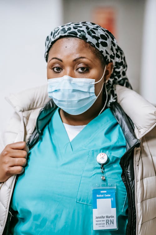 NHS nurse in mask standing in hospital hallway