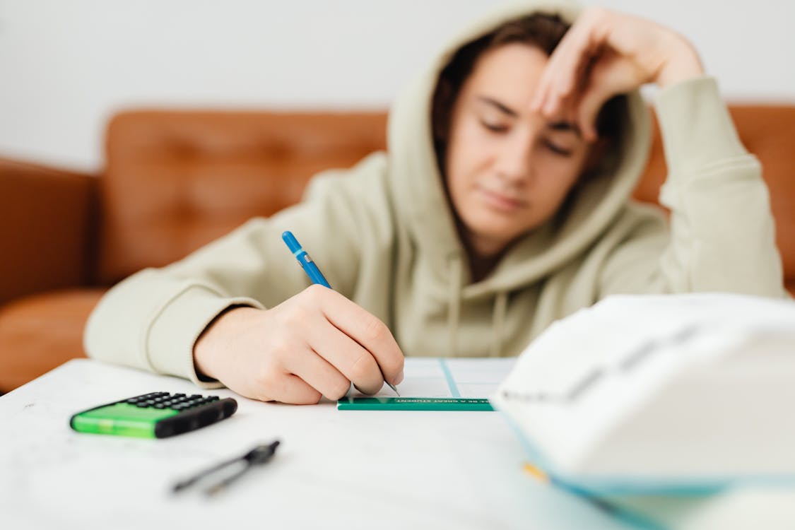 Young man writing on paper for exam preparation