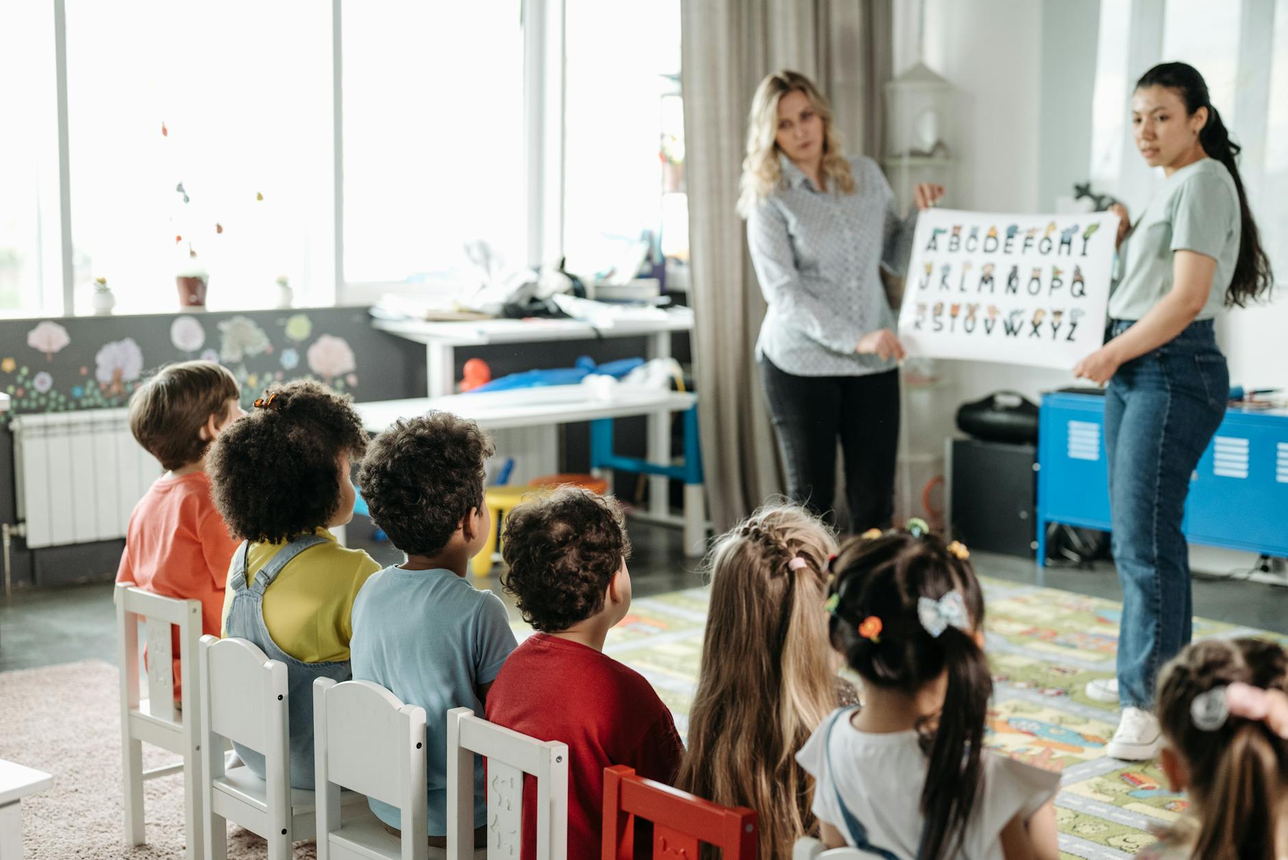 Nursery teacher with children in classroom setting
