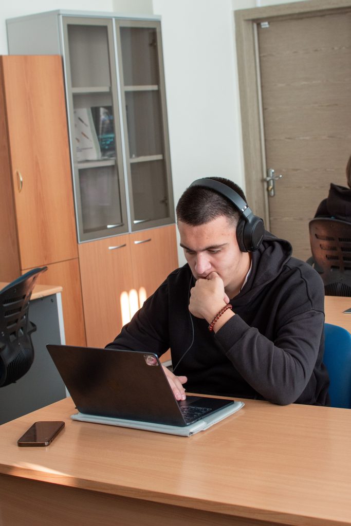 Student studying with headphones and laptop