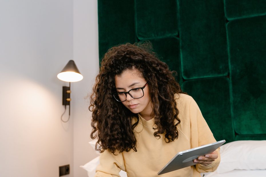 Lady sitting on bed studying on a laptop