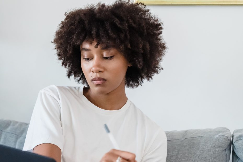Young lady sitting on bed learning with a laptop infront of her